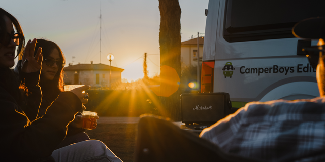 Personen sitzen vor einem Grand California und hören Musik