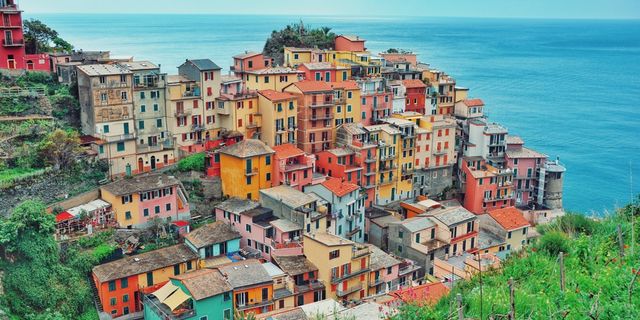 Mountaintop with houses on top and in the background sea