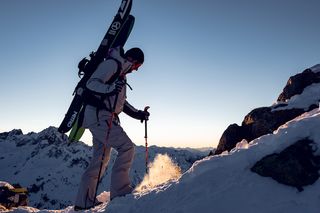 Skitourengänger wandert im Schnee Berg hinauf 