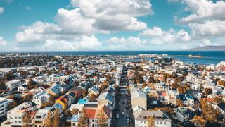 Bunte Häuser in Reykjavík, der Hauptstadt von Island, von oben fotografiert mit Meer und Wolken im Hintergrund