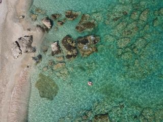 Eine Frau liegt in einem Schwimmreifen im Meer vor dem Elafonisi Strand auf Kreta.