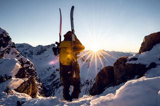 Mann geht Skitour auf verschneiten Bergen