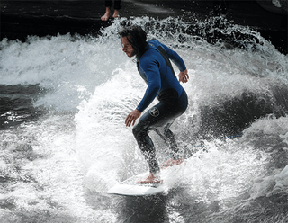 Ein Surfer auf der Eisbachwelle in München