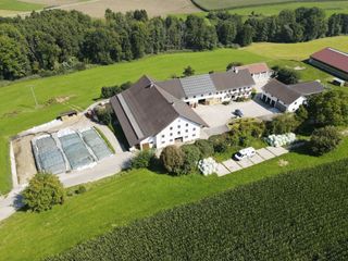 Luftaufnahme von einem Bauernhof mit einem davor geparkten Camper.