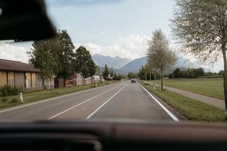 Blick aus dem Camperfenster auf Straße und Berge