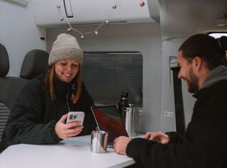 Arbeiten im Camper mit Handy und Laptop