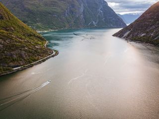 Ein Boot fährt im Sognefjord in Norwegen. Wir verraten dir Norwegen Geheimtipps in diesem Artikel.