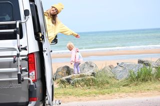 Mutter und Kind winken aus Campervan