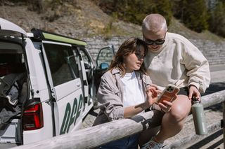 Friends look at cell phone while planning a camping trip to Walchensee